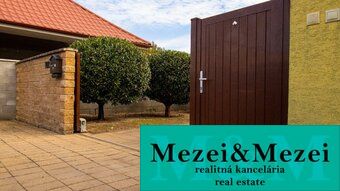 Ein Einfamilienhaus in Majcichov mit befestigter Fläche und gut gepflegtem Grün im Hof.
