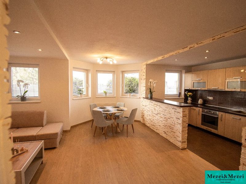 Wohnbereich in einem Einfamilienhaus mit Küche und Esszimmer, Boden mit Holzdekor.