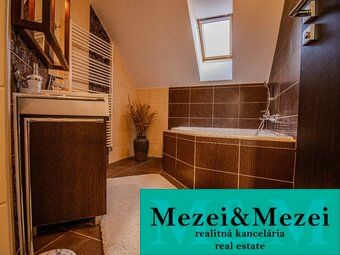 Ein Badezimmer in einem Einfamilienhaus mit einer Badewanne und Holzmöbeldekor.