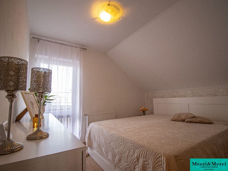 Schlafzimmer im Einfamilienhaus mit Dekorationen, Bett und sanfter Beleuchtung.