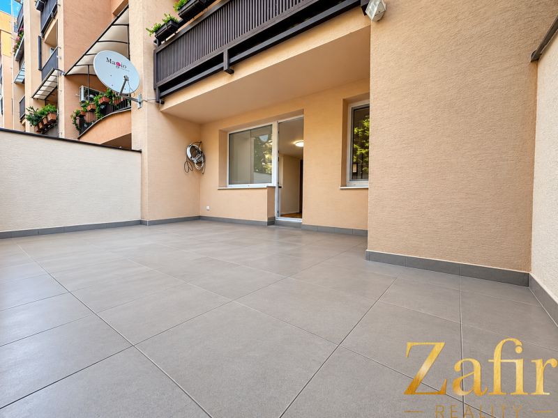 Die Terrasse der 3-Zimmer-Wohnung in der Vajanského-Straße in Trnava mit Fliesen und Grünpflanzen auf dem Balkon.