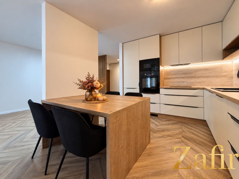 Die Küche in einer 3-Zimmer-Wohnung mit einem Holzboden und einem dekorativen Tisch.