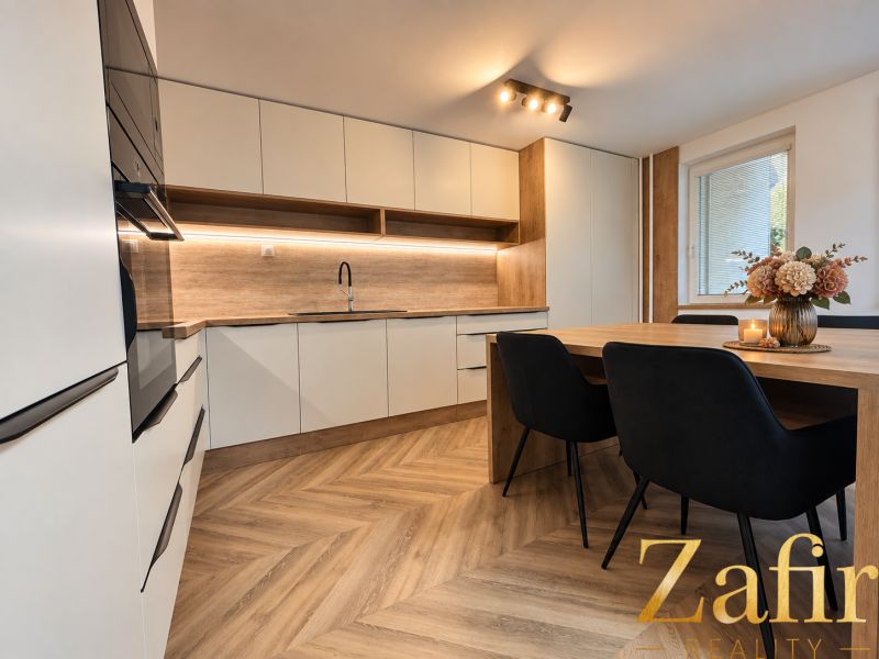 Küche in einer 3-Zimmer-Wohnung mit Holzboden und Esstisch.