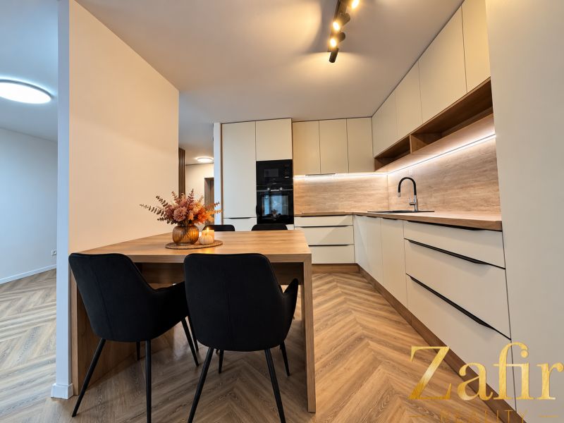 Küche in einer 3-Zimmer-Wohnung mit angenehmer Beleuchtung und einem Boden in Holzoptik.