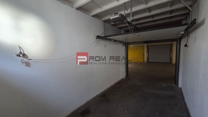 Die Garage hat weiße Wände und einen Mechanismus für das Tor.