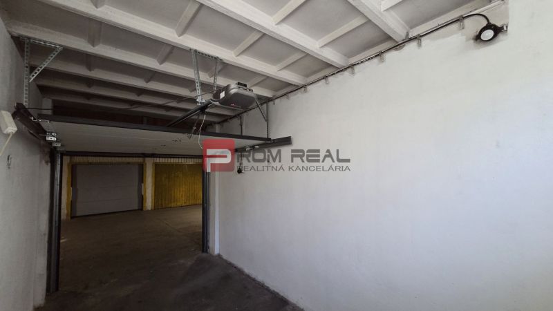 Innenraum einer Garage mit einem automatischen Tor und Betonboden.