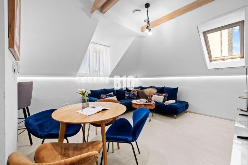 Helles Wohnzimmer in einer Zweizimmerwohnung mit blauem Sofa und Holztisch.