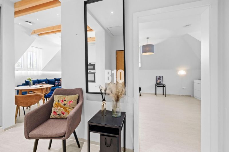 Innenraum einer 2-Zimmer-Wohnung mit Holzboden und Spiegelfrontmöbeln.