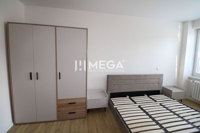 Schlafzimmer in einer 2-Zimmer-Wohnung mit Bett, Nachttischen und Kleiderschrank auf einem Boden mit Holzdekor.