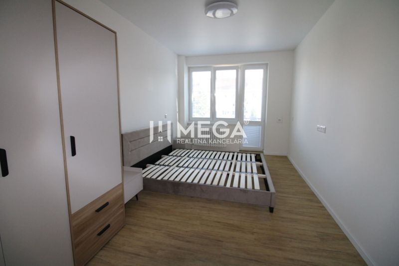 Helles Schlafzimmer in einer 2-Zimmer-Wohnung mit Holzboden und großem Fenster.