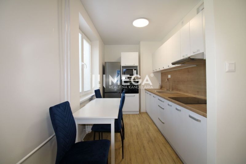 Küche mit Tisch und Holzboden in einer 2-Zimmer-Wohnung.