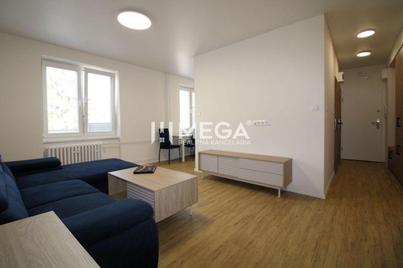 Wohnzimmer mit Sofa, Couchtisch und Holzboden in einer Zweizimmerwohnung.