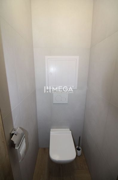 Toilette in einer 2-Zimmer-Wohnung mit Holzboden und hellen Wänden.