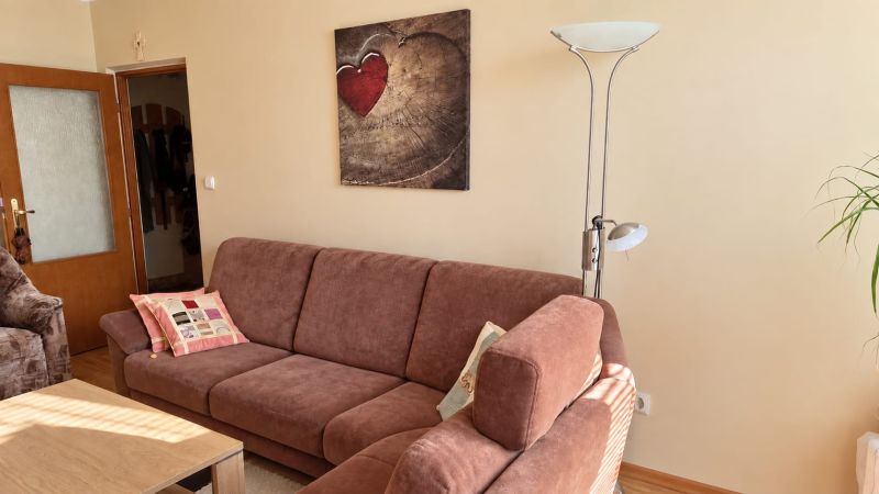 Gemütliches Wohnzimmer mit Sofa, Lampe und Kunstbild in einer 3-Zimmer-Wohnung.