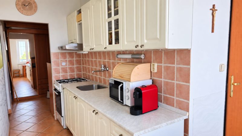 Küche mit weißen Schränken und Keramikfliesen in einer 3-Zimmer-Wohnung.