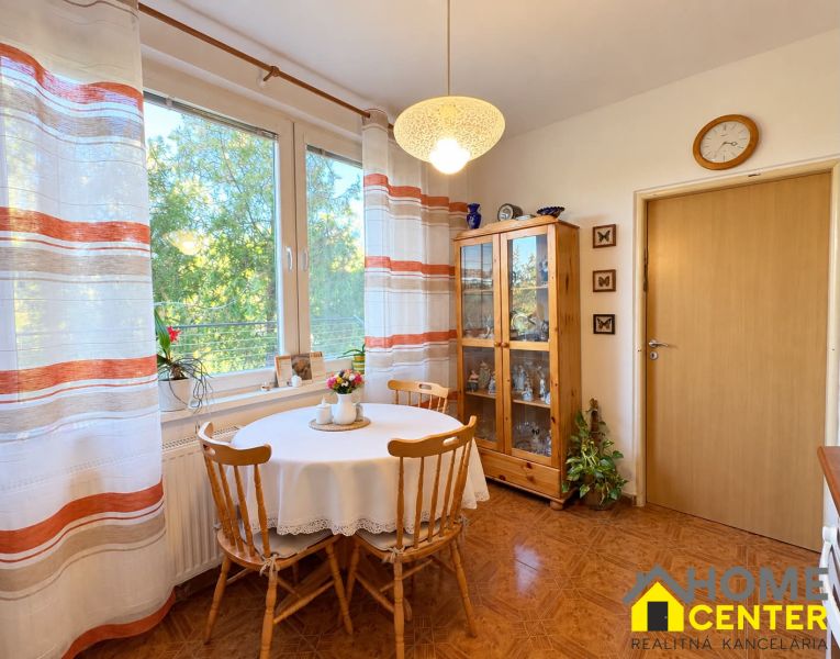 Klarer Küche in einer 3-Zimmer-Wohnung mit Holzboden und Esstisch.