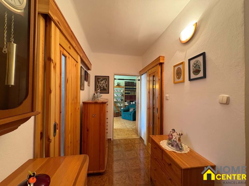 Flur in einer 3-Zimmer-Wohnung mit Holzboden und Holzmöbeln.