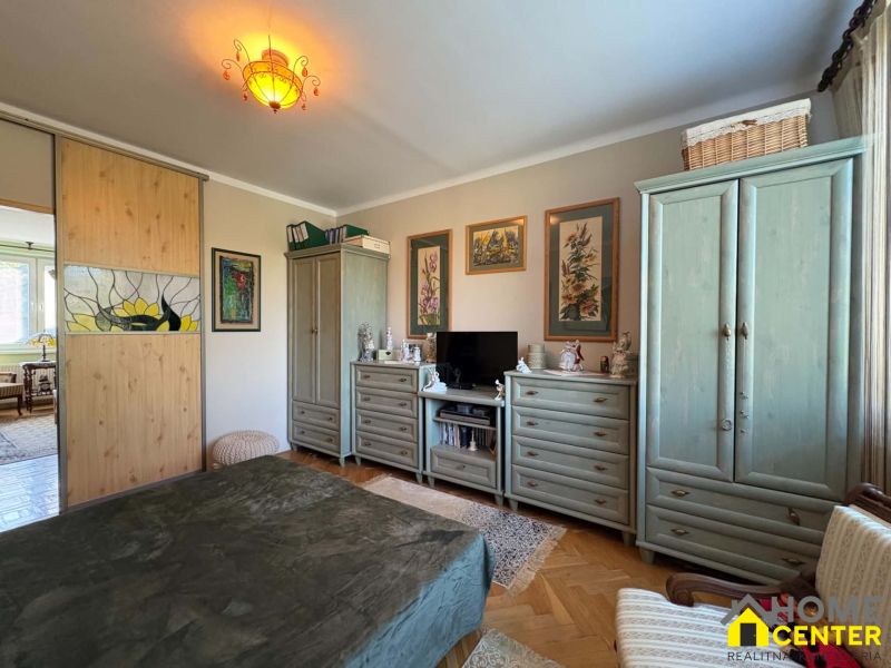 Schlafzimmer in einer 3-Zimmer-Wohnung mit dekorativer Beleuchtung, Schrank und Kommode.
