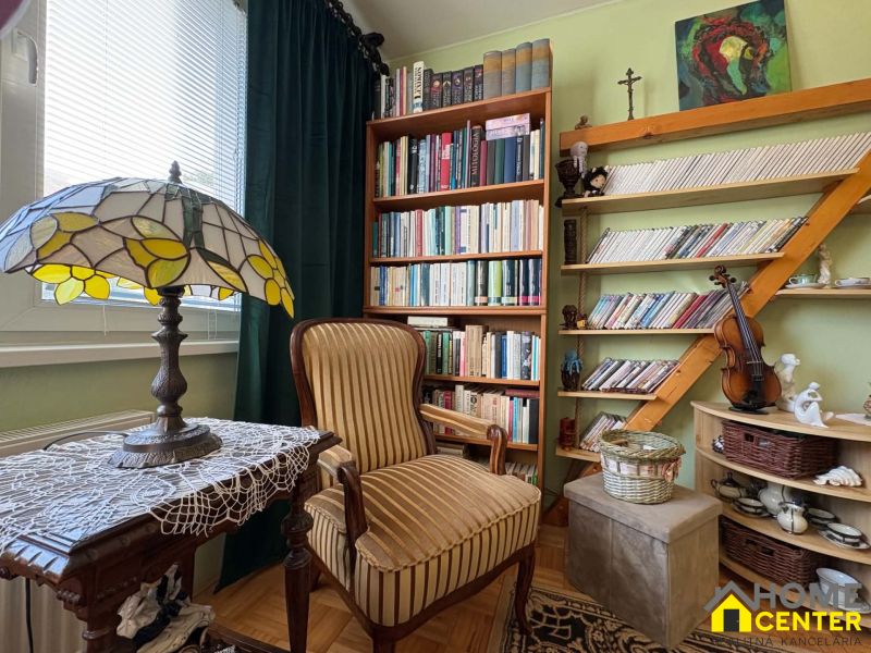 Ein Bücherregal mit vielen Büchern und Dekorationen in einer 3-Zimmer-Wohnung, Boden mit Holzdekor.