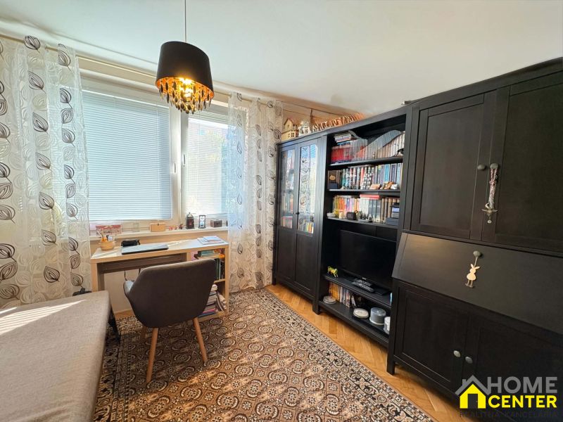 Arbeitsbereich mit Schreibtisch, Stuhl und Schränken, 3-Zimmer-Wohnung, Boden mit Holzdekor.