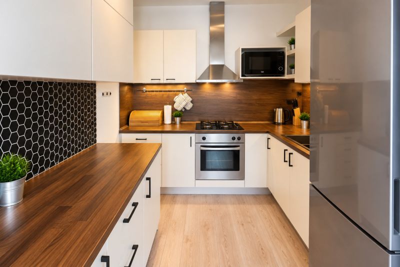 Küche in einer 2-Zimmer-Wohnung mit Holzdekor und schwarzen sechseckigen Fliesen.