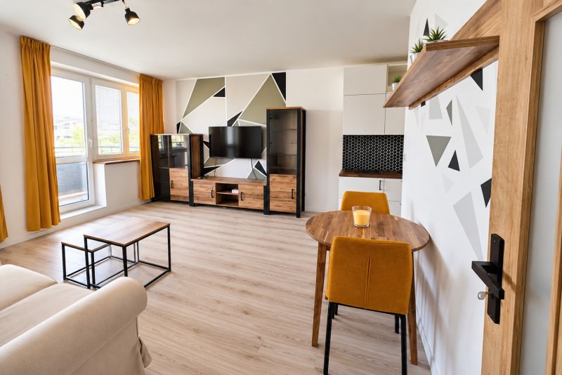 Helles Wohnzimmer mit bunten Details und Holzboden in einer 2-Zimmer-Wohnung.