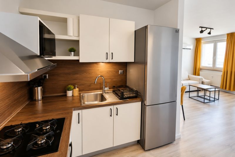 Eine Küche mit Holzboden und Edelstahlgeräten in einer Zweizimmerwohnung.