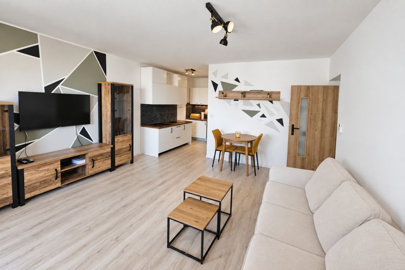 Wohnzimmer mit Küchenzeile und Holzboden in einer 2-Zimmer-Wohnung.