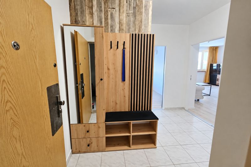 Eingangsflur mit Holzmöbeln und Fliesen in einer 2-Zimmer-Wohnung.