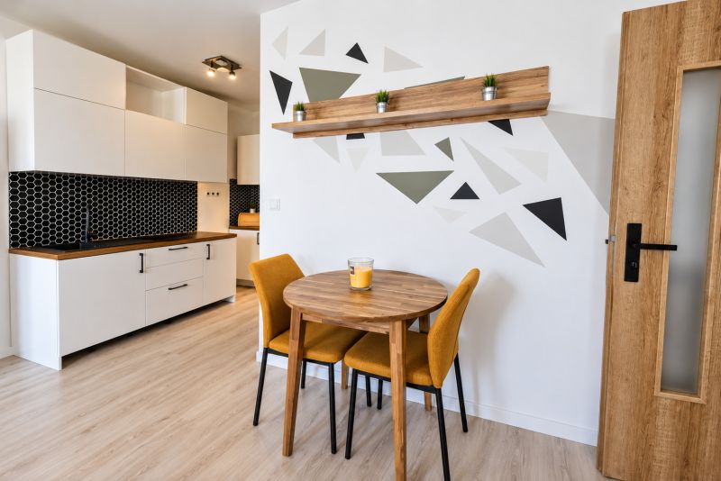 Küchenecke in einer 2-Zimmer-Wohnung mit einem Holzboden und einer Wand mit geometrischem Design.