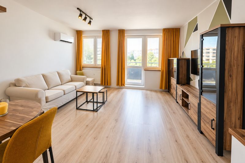 Wohnzimmer mit Sofa und Holzboden in einer Zweizimmerwohnung.
