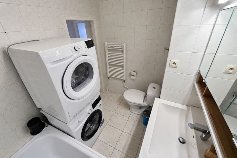 Badezimmer mit Geräten und Sanitäranlagen in einer 2-Zimmer-Wohnung, Keramikfliesen und Bodenfliesen.