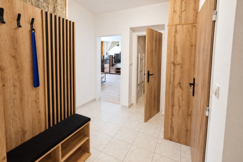 Flur mit Garderobe und Eingang zum Wohnzimmer in einer 2-Zimmer-Wohnung, Holzelemente.