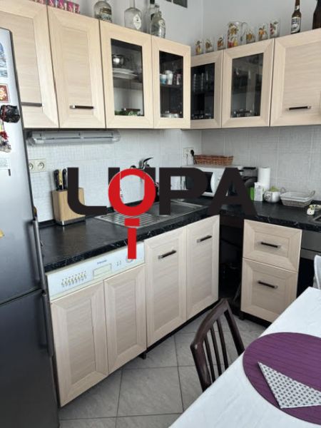 Küche in einer 2-Zimmer-Wohnung mit Holzmöbeldekor und hellen Fliesen.