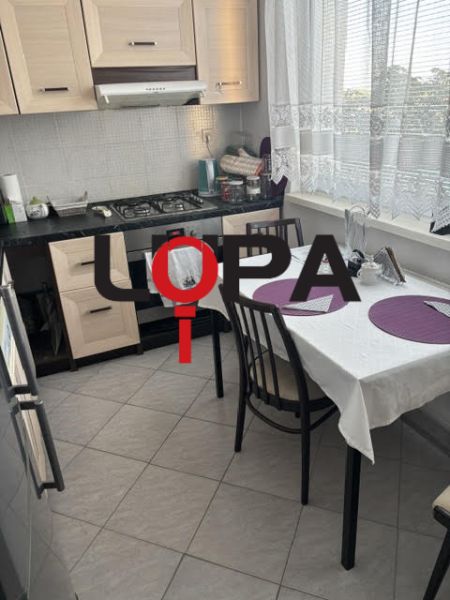 Küche in einer 2-Zimmer-Wohnung mit Esstisch und Küchenzeile.