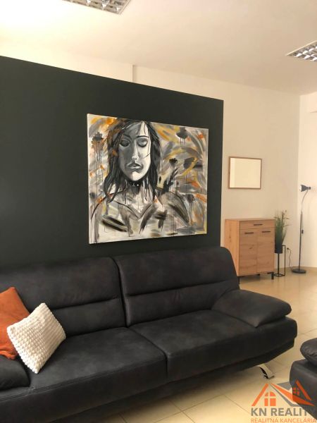 Wohnzimmer mit grauem Sofa, auffälligem Bild und hellem Fliesenboden in einer 2-Zimmer-Wohnung.