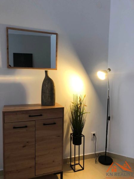 Spiegel, Schrank mit Holzboden und Lampe schaffen eine Atmosphäre in einer 2-Zimmer-Wohnung.