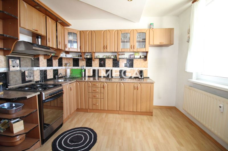 Eine Küche in einer 3-Zimmer-Wohnung mit einem Boden in Holzoptik und einer funktionalen Küchenzeile.