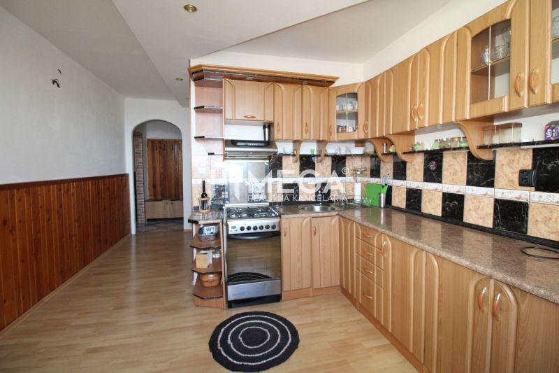 Küche in einer 3-Zimmer-Wohnung mit Holzboden und gebogenem Schrank.