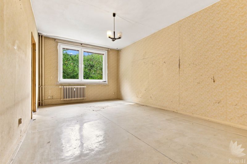 Ein Zimmer mit Tapeten, einem Heizkörper und einem Holzboden-Dekor. Eine 2-Zimmer-Wohnung.
