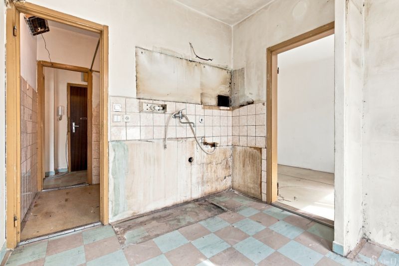 Verlassene Küche mit Fliesen und Fliesenboden in einer 2-Zimmer-Wohnung.