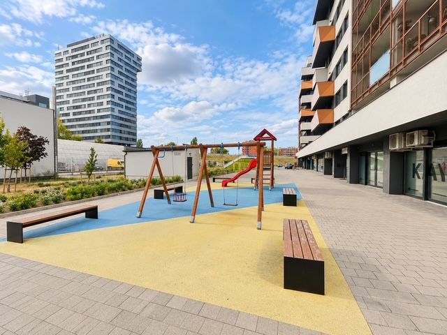 Spielplatz mit Bänken auf dem Muchovo námestie in Bratislava, vor einer 2-Zimmer-Wohnung.