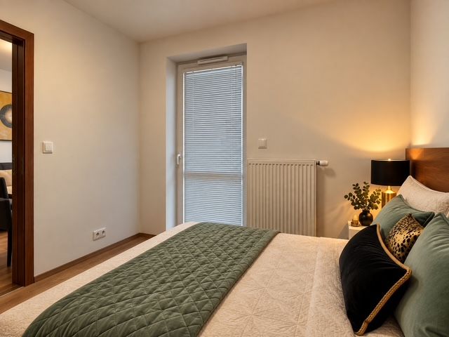Schlafzimmer in einer 2-Zimmer-Wohnung mit grüner Decke und Holzboden.