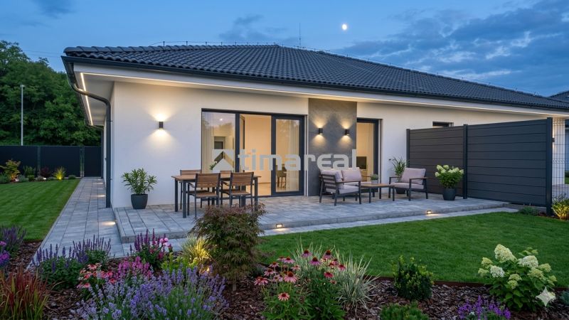 Ein Einfamilienhaus in Hôrka nad Váhom mit Terrasse, Beleuchtung und Garten am Abend.