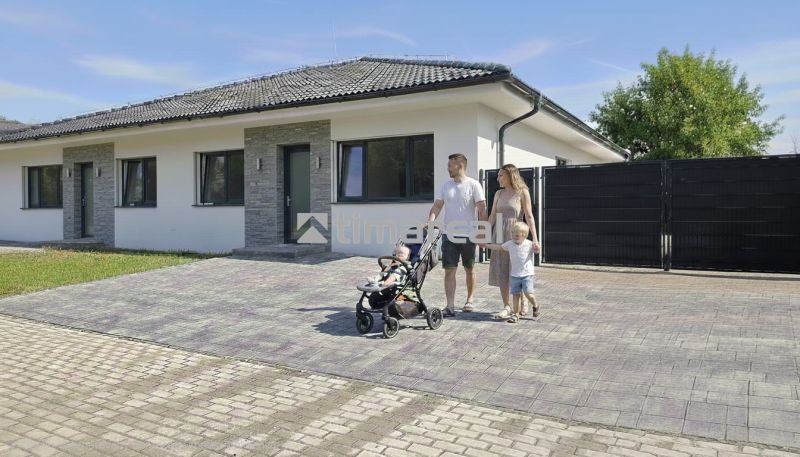 Ein Einfamilienhaus in Hôrka nad Váhom mit einer Familie auf der gepflasterten Zufahrt.