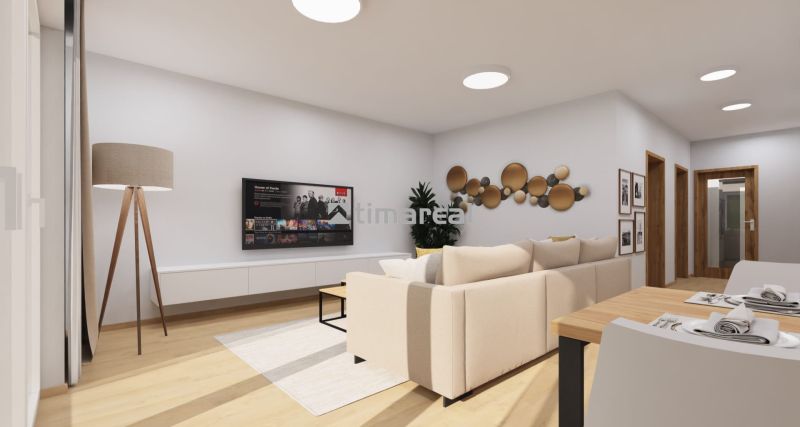 Wohnzimmer mit bequemer Couch, Couchtisch und Fernseher, Boden mit Holzdekor.