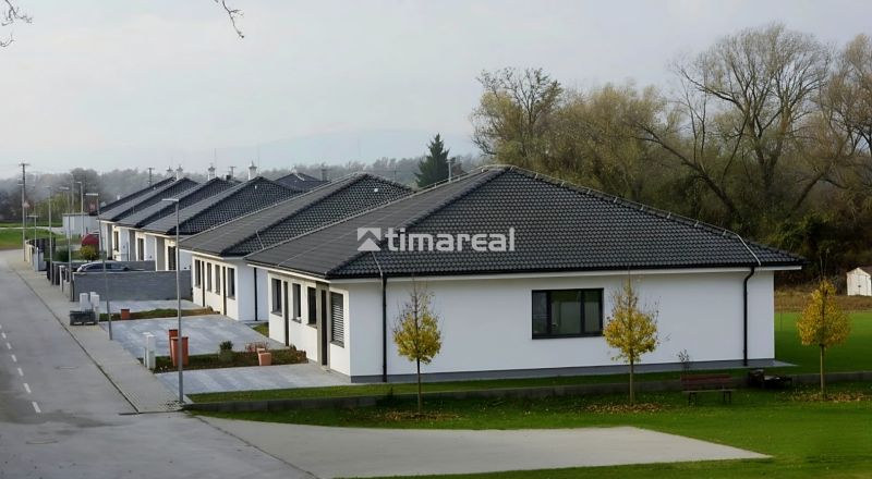 Einfamilienhäuser mit dunklem Dach in Hôrka nad Váhom, umgeben von Grün und einer Straße.