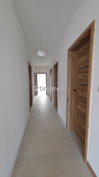 Der Flur in einem Einfamilienhaus mit Holztüren und beigem Boden.