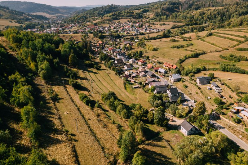 Luftaufnahme von Häusern und Wiesen in Čierny Balog, Školská Straße, umgeben von Erholungsgrundstücken.