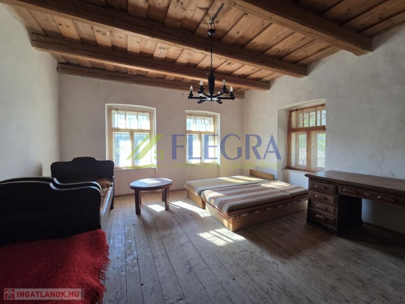 Schlafzimmer in einem Einfamilienhaus mit Holzdecke und Boden in Holzoptik.